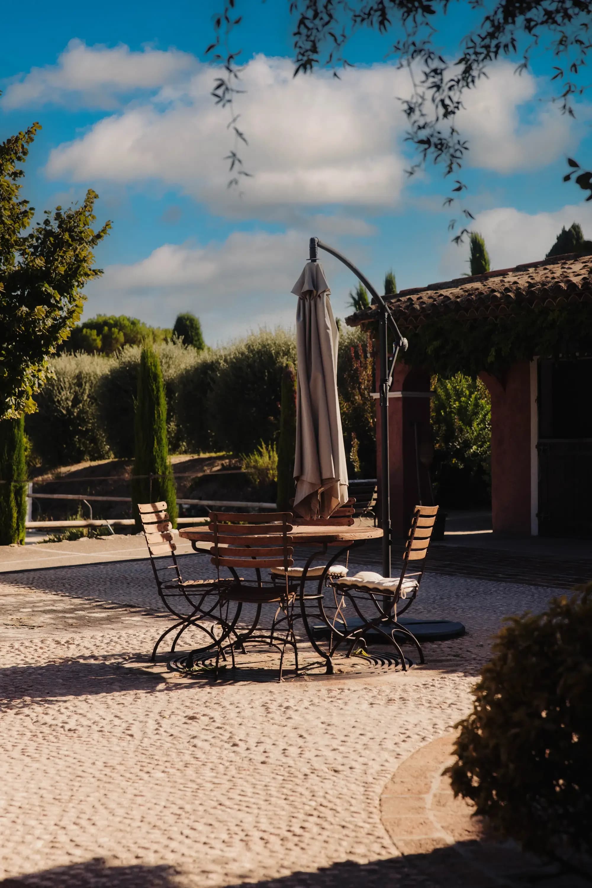 Shaded terrace with a table and chairs in the stable courtyard
